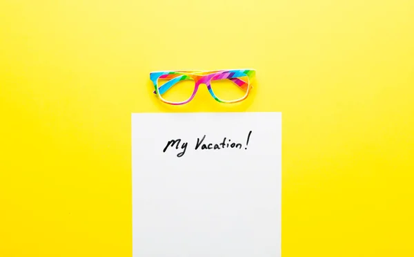แว่นตาและกระดาษที่มีตัวอักษร "วันหยุดของฉัน!" อยู่บนโต๊ะ — ภาพถ่ายสต็อก