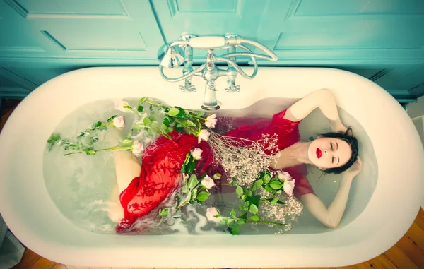 年轻女性在浴缸与花 — 图库照片