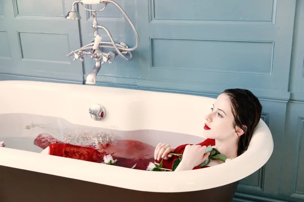Молода жінка в ванні з квітами — стокове фото