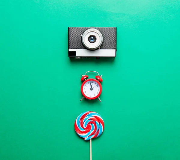 Camera, alarm clock and candy — Stock Photo, Image