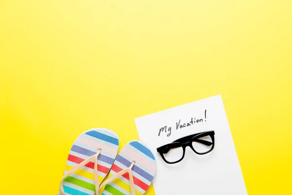 Sandálias e papel com letras "minhas férias!" na mesa — Fotografia de Stock