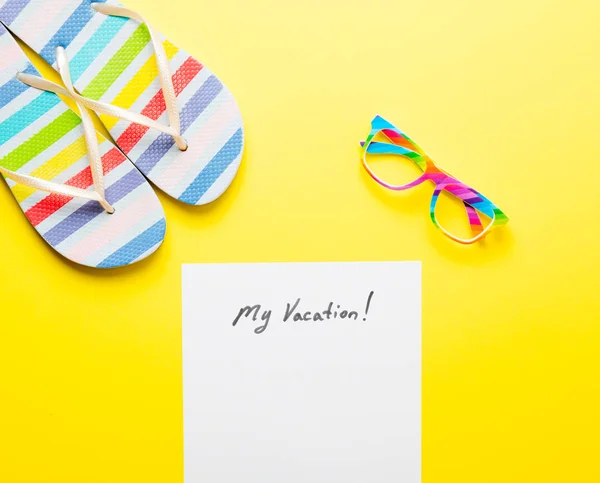 Sandálias e papel com letras "minhas férias!" na mesa — Fotografia de Stock