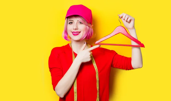 Frau mit Kleiderbügel und Maßband — Stockfoto