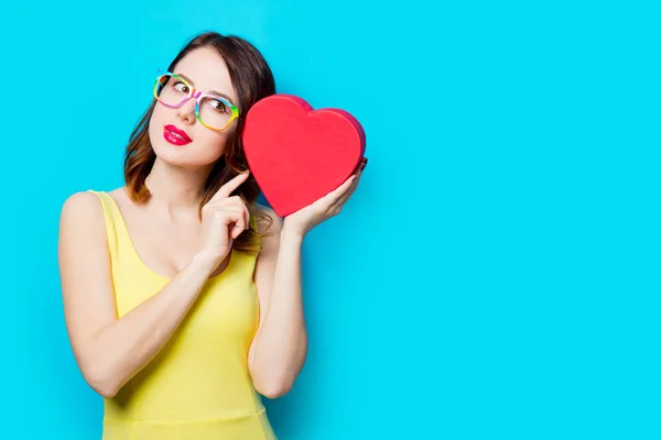 Jeune femme avec cadeau en forme de coeur — Photo