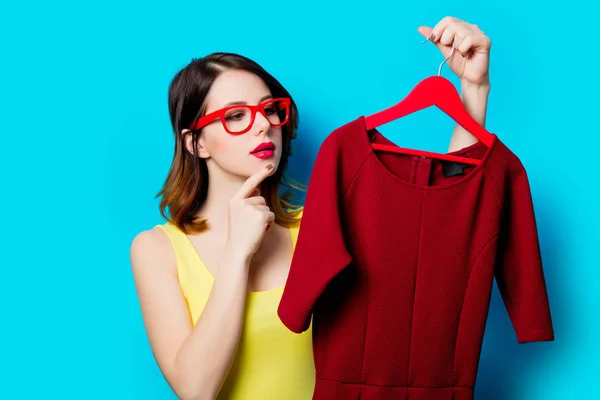 Jovem mulher segurando vestido no cabide — Fotografia de Stock