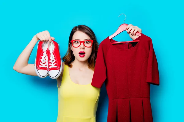 Young woman holding dress on hanger — Stock Photo, Image