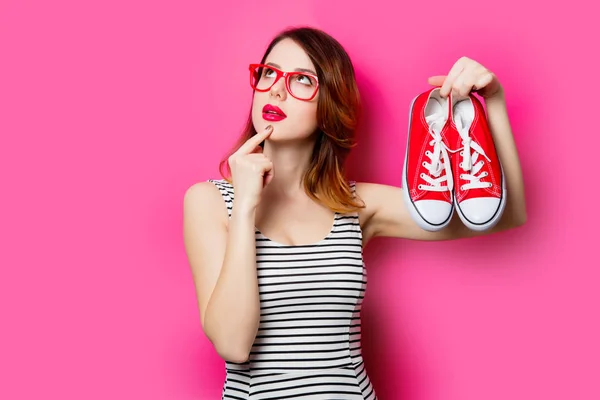 Mujer joven con zapatos de goma rojos — Foto de Stock