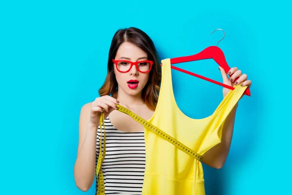 Mujer joven sosteniendo camisa en percha —  Fotos de Stock