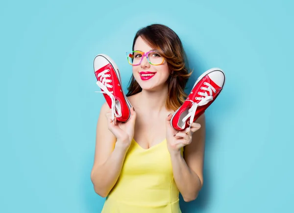 Mujer joven con zapatos de goma rojos — Foto de Stock