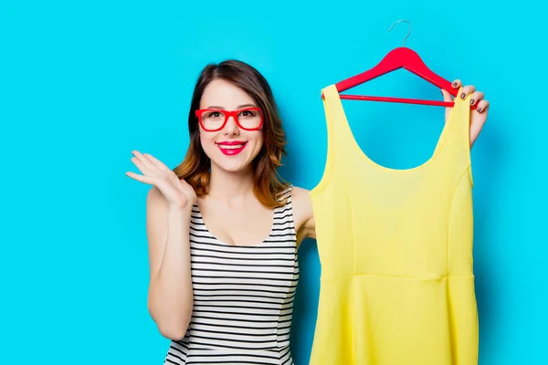 Jovem mulher segurando camisa no cabide — Fotografia de Stock