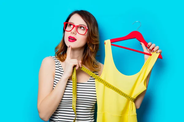 Jonge vrouw met shirt op hanger — Stockfoto