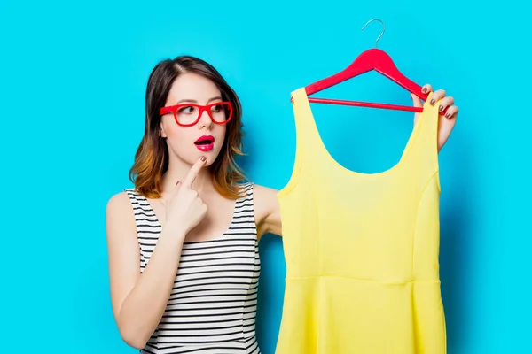 Jonge vrouw met shirt op hanger — Stockfoto