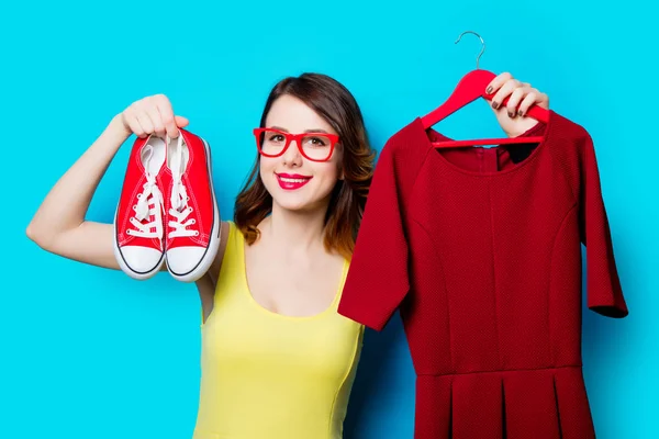 Mujer joven sosteniendo vestido en percha — Foto de Stock