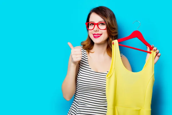 Young woman holding shirt on hanger — Stock Photo, Image