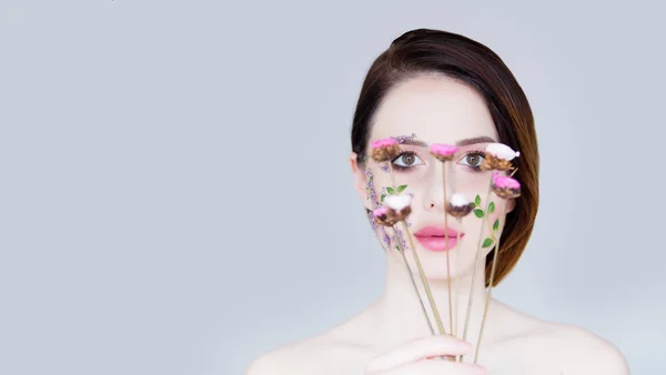 Beautiful young woman with flowers on cheeks — Stock Photo, Image