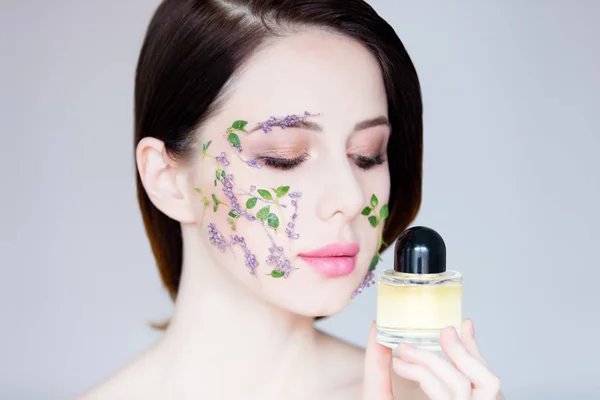 Beautiful young woman with flowers on cheeks — Stock Photo, Image