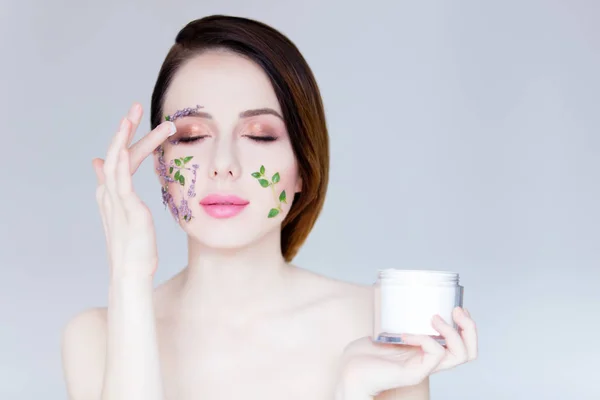 Hermosa joven con flores en las mejillas — Foto de Stock