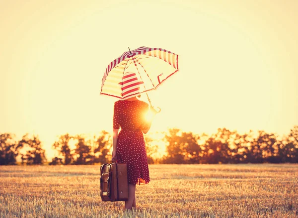 Krásná mladá žena s kufrem a deštníkem — Stock fotografie