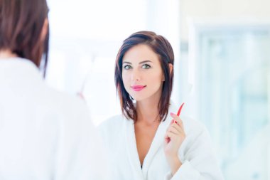 Diş fırçası olan genç bir kadın.