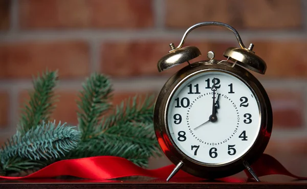 Alarm clock, fir branch and ribbon — Stock Photo, Image