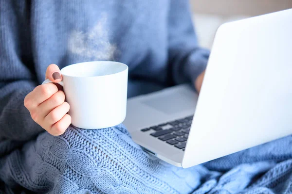 Female hands with cup and laptop — Stock Photo, Image