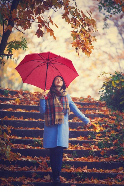 Γυναίκα που κρατά ομπρέλα και φθινοπωρινά φύλλα — Φωτογραφία Αρχείου