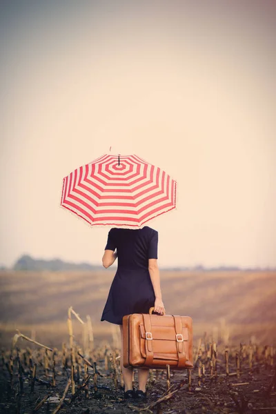 Женщина с чемоданом и зонтиком — стоковое фото