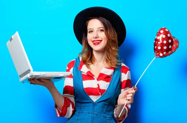 Mulher sorridente com laptop e coração — Fotografia de Stock