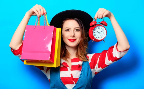 Mujer con despertador y bolsas — Foto de Stock