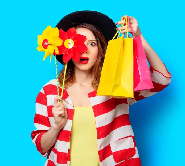 Γυναίκα με pinwheel και τσάντες για ψώνια — Φωτογραφία Αρχείου