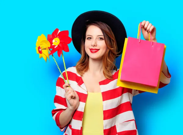 Nő pinwheels és bevásárló táskák — Stock Fotó