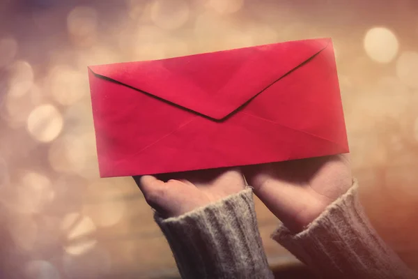 Жіночі руки тримають великий червоний конверт — стокове фото