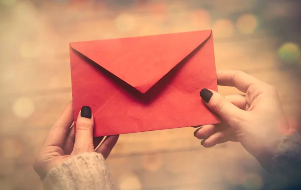 Mãos segurando grande envelope vermelho — Fotografia de Stock