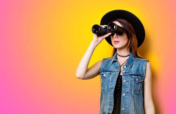 Portrait of young adult woman in hat with binocular