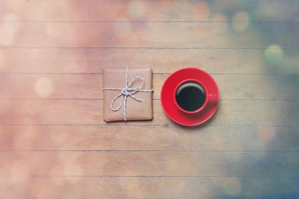 Red Cup of coffee with gift — Stock Photo, Image