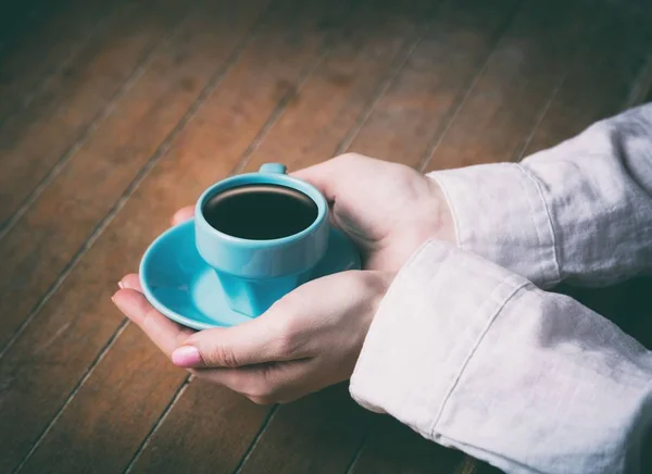 Mulheres mãos segurando pouco azul xícara de café — Fotografia de Stock