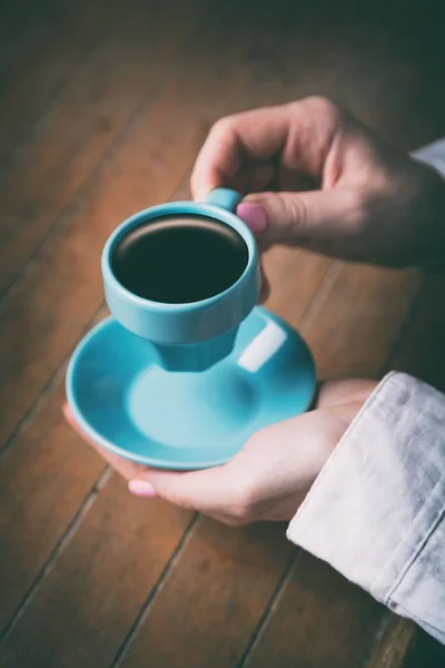 Mulheres mãos segurando pouco azul xícara de café — Fotografia de Stock