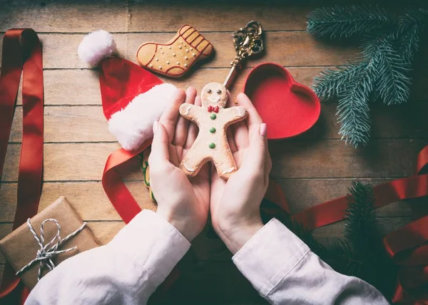 Hands wrapping christmas gingerbread man cookies — Stock Photo, Image