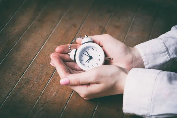 Young woman hands holding white alarm clock — Stock Photo, Image