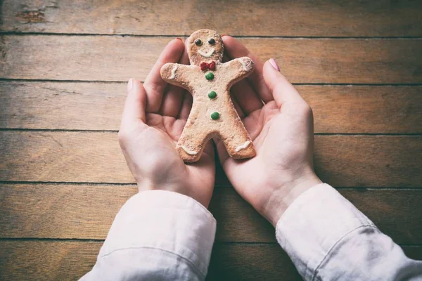 Mani che tengono Natale pan di zenzero uomo biscotto — Foto Stock