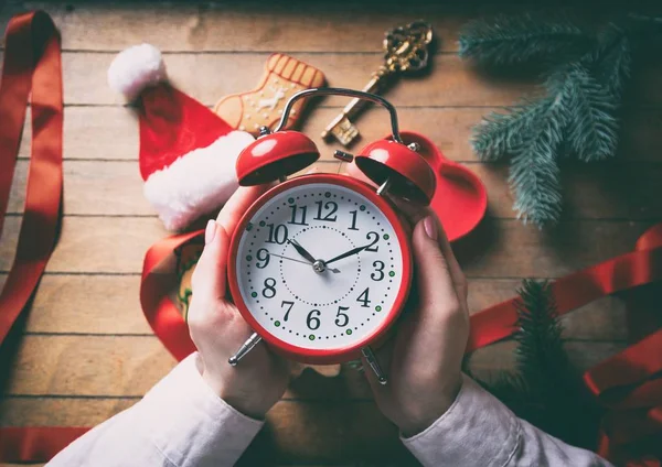 Mujer manos envolviendo reloj despertador de Navidad —  Fotos de Stock