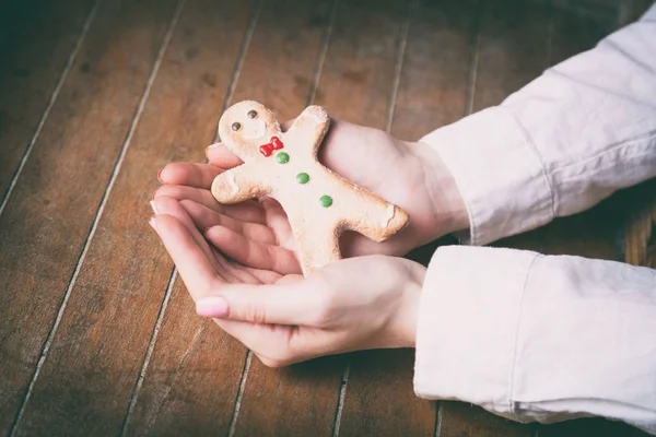 Hands holding christmas gingerbread man cookie — Stock Photo, Image