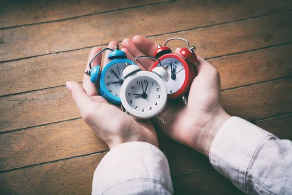 Jonge vrouw handen bedrijf alarmklokken — Stockfoto