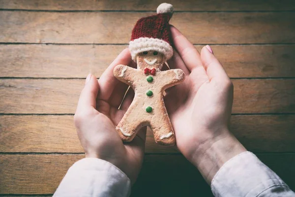 Hands holding christmas gingerbread man cookie — Stock Photo, Image