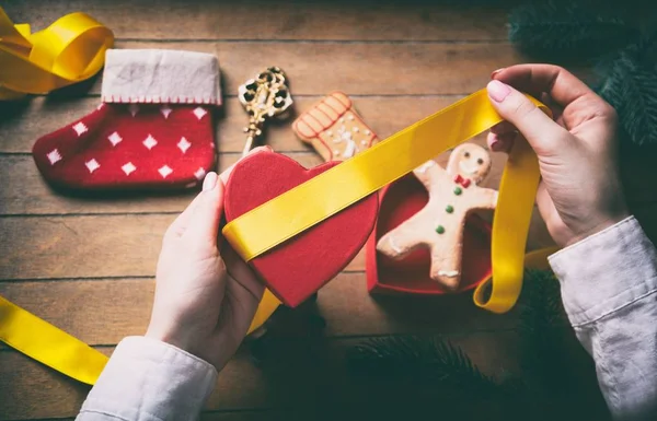 Mains enveloppant cadeaux de Noël et biscuits — Photo