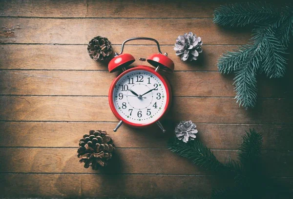 Reloj despertador rojo de Navidad y conos de pino — Foto de Stock