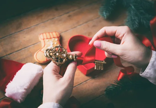 Ręce, zawijanie Boże Narodzenie złoty klucz i prezenty — Zdjęcie stockowe