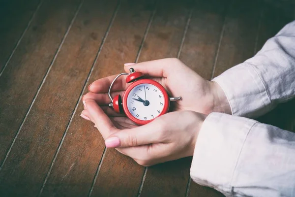 ผู้หญิงสาวถือนาฬิกาปลุกสีแดง — ภาพถ่ายสต็อก