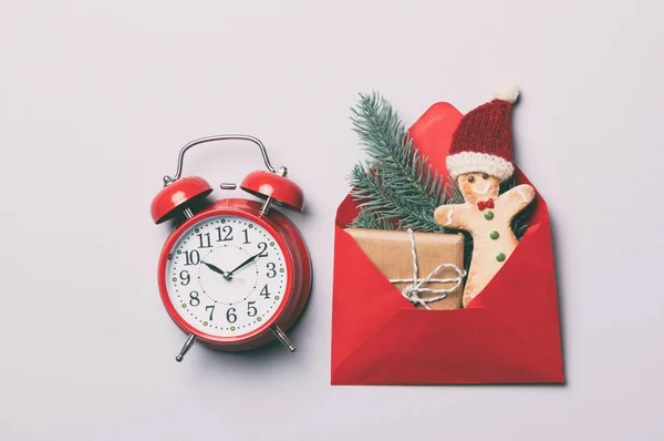 Kırmızı alarm saati ve Noel hediyeleri zarf içinde — Stok fotoğraf