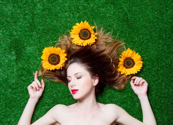 Ragazza dai capelli rossi con girasoli sull'erba — Foto Stock